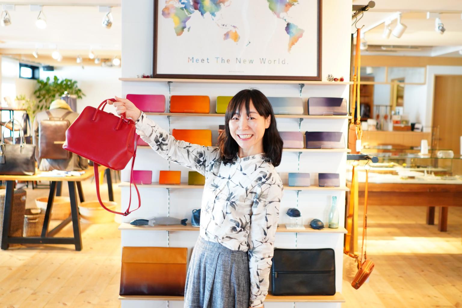 Motherhouse founder Eriko Yamaguchi holding a red leather handbag at the brand's first Singapore store opening in March 2020.